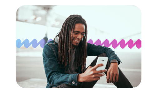 Global Telecom Man sitting and smiling while using his mobile device