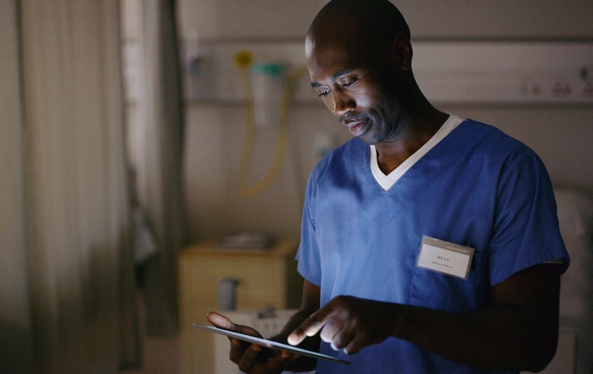 Fotografia de um médico utilizando um tablet digital para consultar um gráfico médico