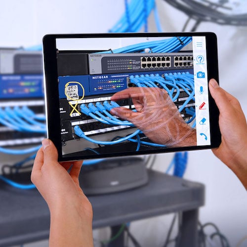 Mulher olhando para o telefone enquanto conserta o equipamento