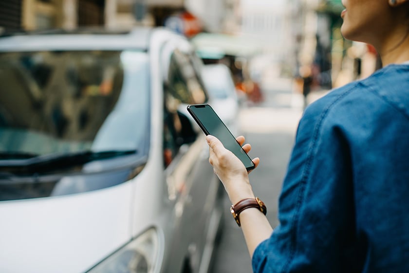 Mulher ao telefone olhando para um carro