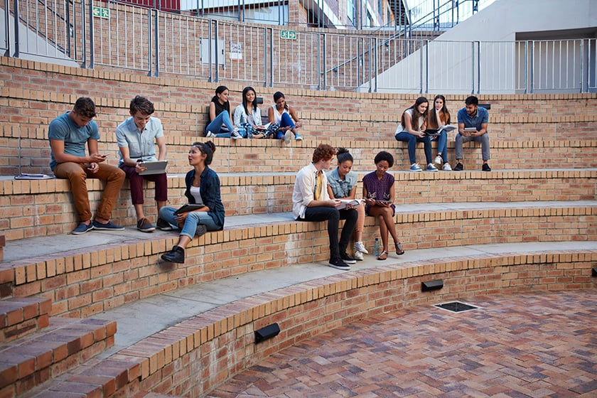Alunos estudando em grupos ao ar livre no campus